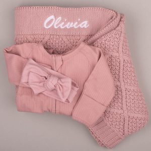 Personalised blush pink baby blanket with Olivia embroidery, matching ribbed onesie and bow headband.