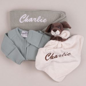 Personalised baby gift set with sage green blanket, puppy comforter, and matching onesie embroidered with name Charlie.