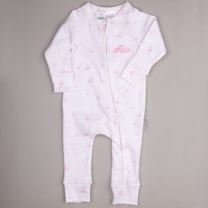 White baby onesie with pale pink butterfly pattern, front zipper, and embroidered name ‘Isla.’
