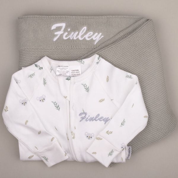 Green Sage Blanket Koala Onesie Finley White koala-print baby onesie with name βFinley,β displayed on a sage green knitted blanket with matching embroidery.