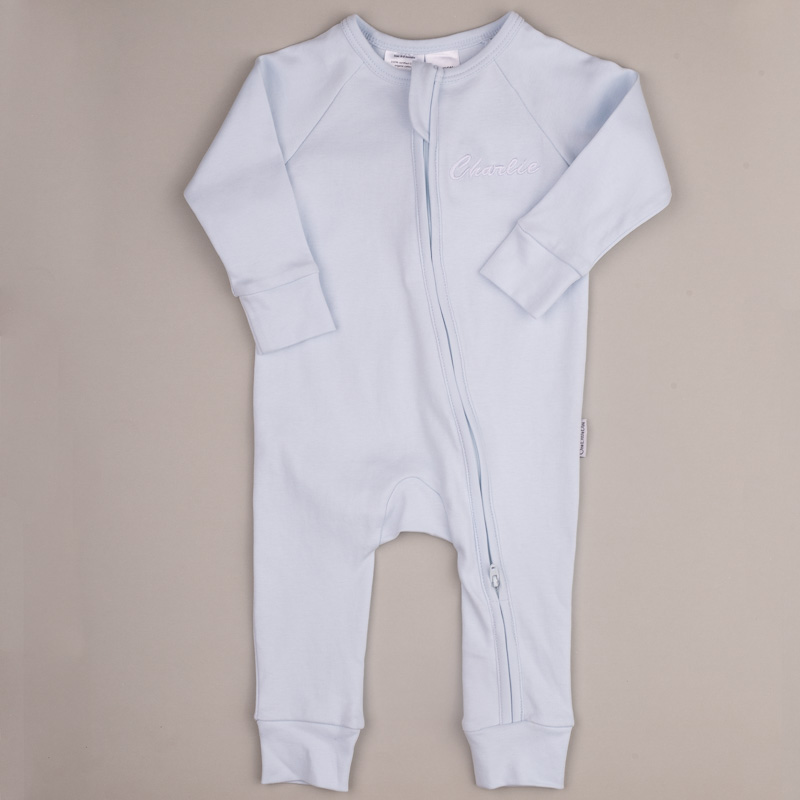 Organic Cotton Blue Zip Onesie Blue baby onesie with front zipper and white embroidered name ‘Charlie.’