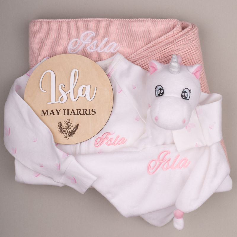 Personalised pink baby gift set with blanket, unicorn comforter, name disc and embroidered onesie for Isla.