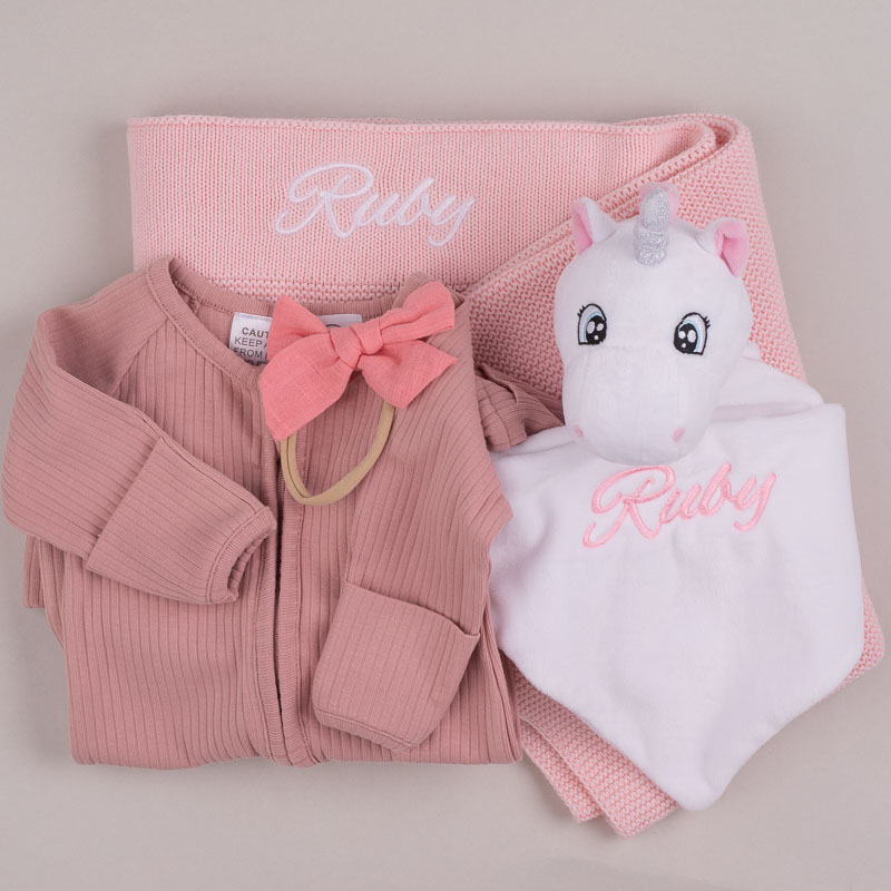 Pink Knitted Blanket, Unicorn & Onesie Baby Gift Personalised baby gift set with pink blanket, unicorn comforter, and ribbed onesie embroidered with name Ruby.