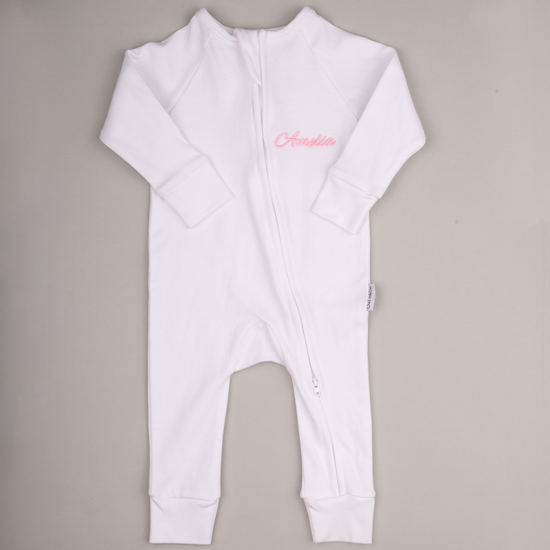 White Baby Onesie Amelia White baby onesie with front zipper and pink embroidered name ‘Amelia.’