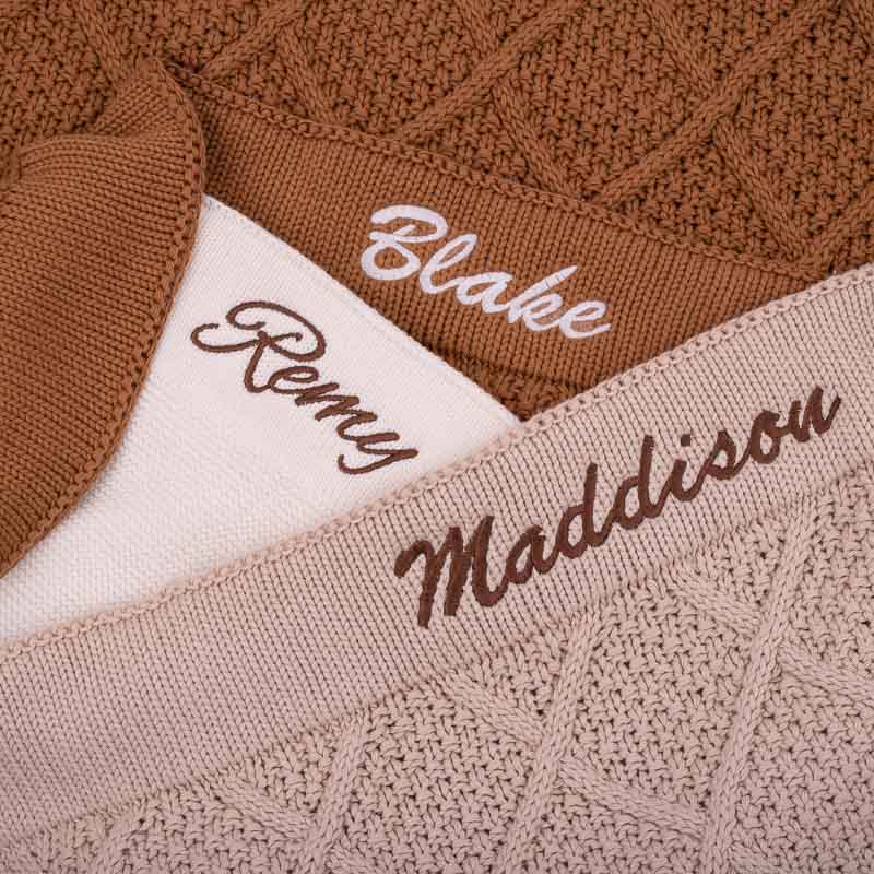Neutral personalised knitted baby blankets with embroidered names.