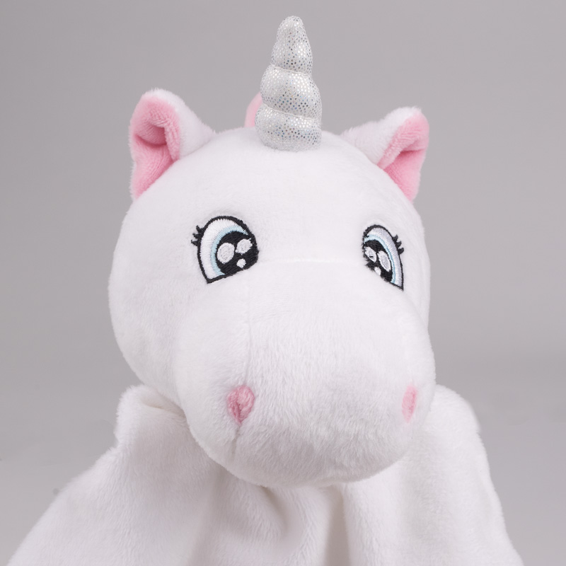 Close-up of white unicorn baby comforter with silver horn.
