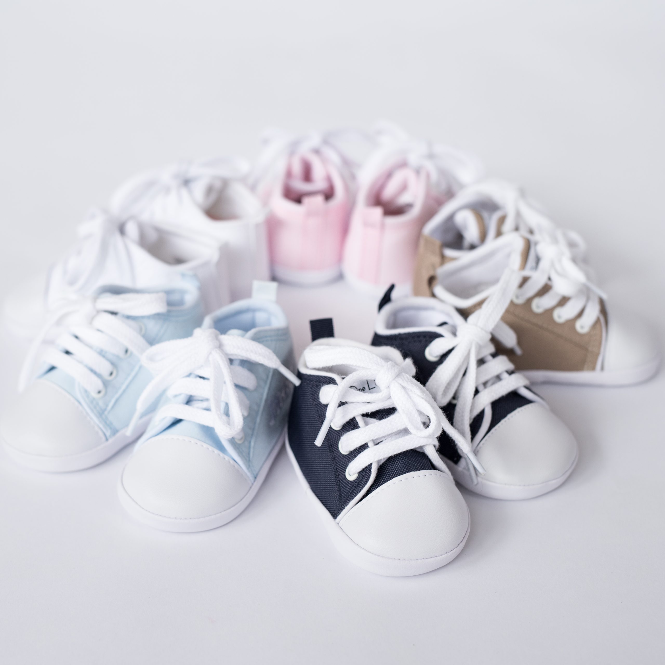 Range of personalised baby shoes in soft blue and navy tones.