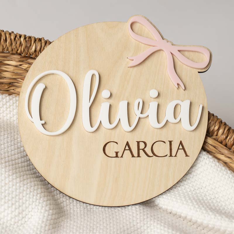 Wooden birth announcement disc with pink 3D bow and name.