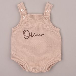 Beige knitted baby romper embroidered “Oliver” in brown script.