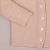 Beige Knitted Cardigan Sleeve Button Close Close-up of beige knitted baby cardigan showing sleeve, buttons, and textured knit detail.
