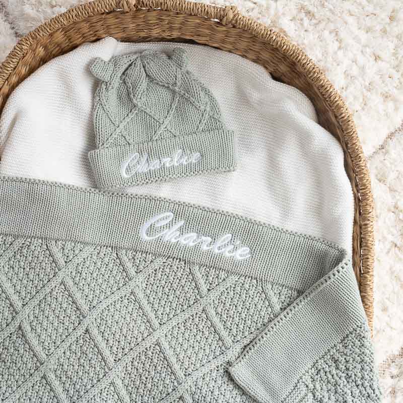 Personalised sage green knitted baby blanket and matching beanie set.