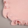 Pink Frill Long Sleeve Baby Romper Close Up Bottom Close-up of pink knit baby romper ruffle hem with pink buttons at crotch snap fastening