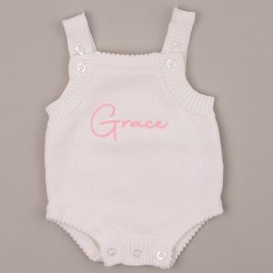 White knitted baby romper embroidered with the name “Grace” in pink script.