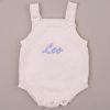 White Knitted Baby Boy Romper With Name Leo White knitted baby romper embroidered “Leo” in blue script.