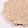 Beige Long Sleeve Baby Romper Close Up Bottom Close-up of beige chunky knit baby romper showing pearl button fastening detail at hem