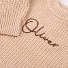 Beige Long Sleeve Baby Romper Close Up Name Close-up of personalised beige chunky knit baby romper showing brown embroidered name and ribbed sleeve detail