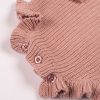Blush Pink Long Sleeve Baby Romper Close Up Bottom Close-up of blush pink chunky knit frilly baby romper showing ruffle hem detail and pink button fastening
