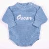 Long Sleeve Blue Baby Romper White Text Oscar Personalised blue chunky knit long sleeve baby romper with white embroidered name and button shoulders