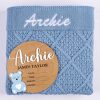 Blue Diamond Knit And Bear Boy Birth Announcment Disc. Archie Blue diamond knitted personalised baby blanket with white embroidered script name displayed alongside a wooden bear birth announcement disc with blue acrylic bear and birth detail fields.
