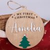 My First Christmas Tree Disc Amelia Personalised wooden Christmas bauble engraved with My First Christmas and Amelia in white with green tree detail