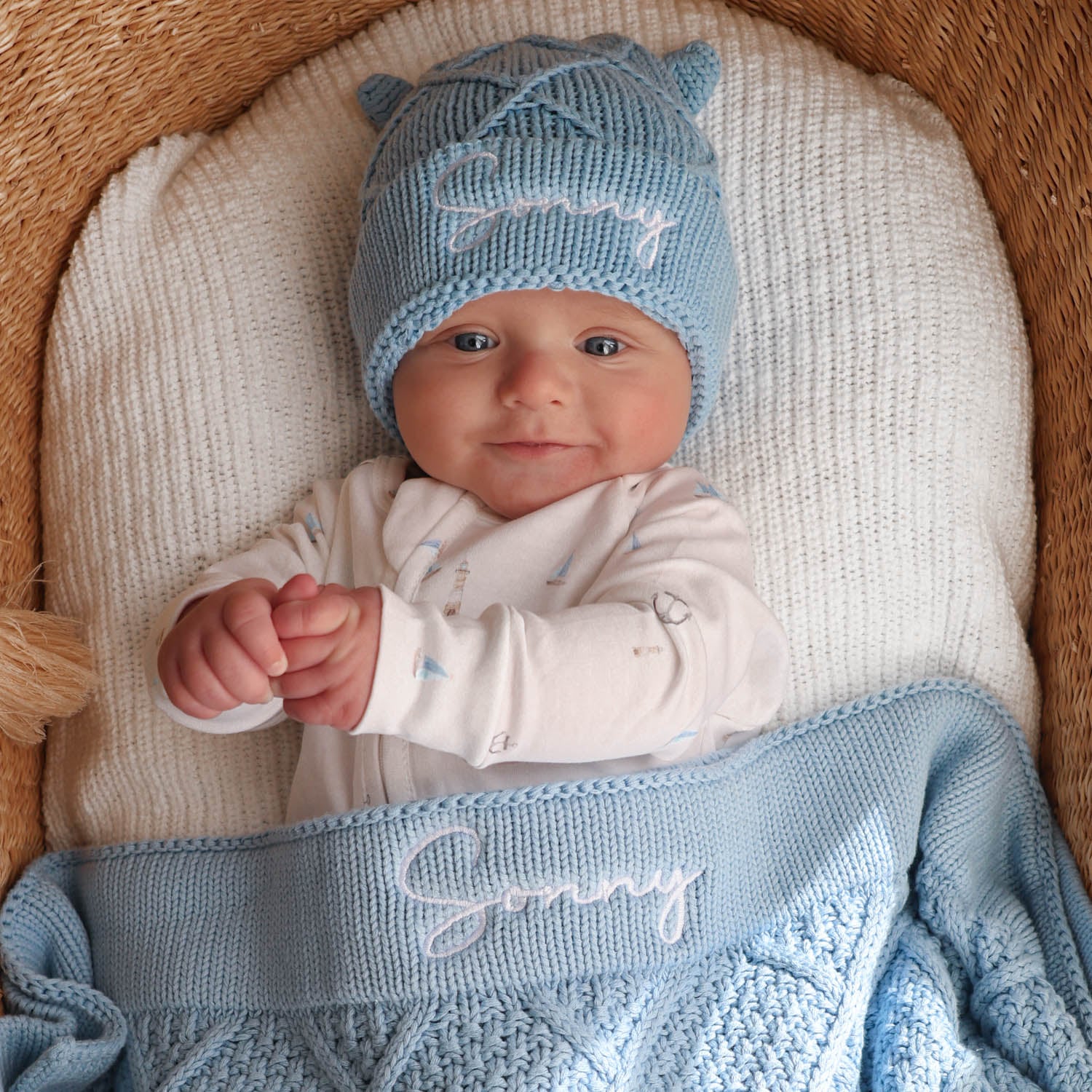 Baby Sonny wearing a personalised blue knitted beanie with bear ears and matching blue diamond knitted blanket gift set.